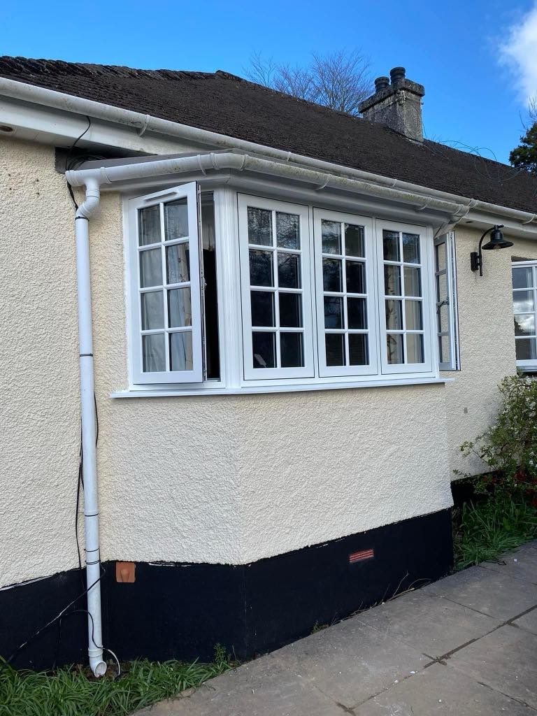 Professional window installation in progress on a residential property in Tavistock Devon, showing a fitter securing a new double-glazed window into place with clean, modern white uPVC framing