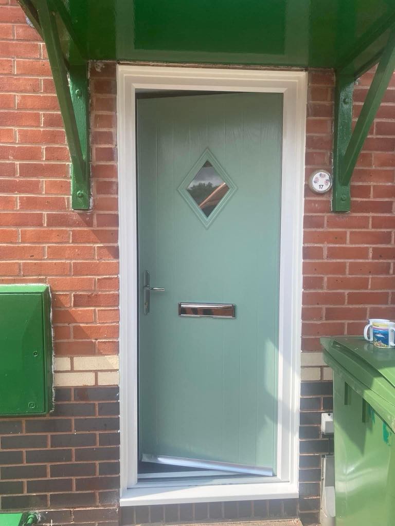 Newly installed sleek sage green front door on a residential home in Ivybridge Devon, featuring a modern design with chrome handle and letterbox.