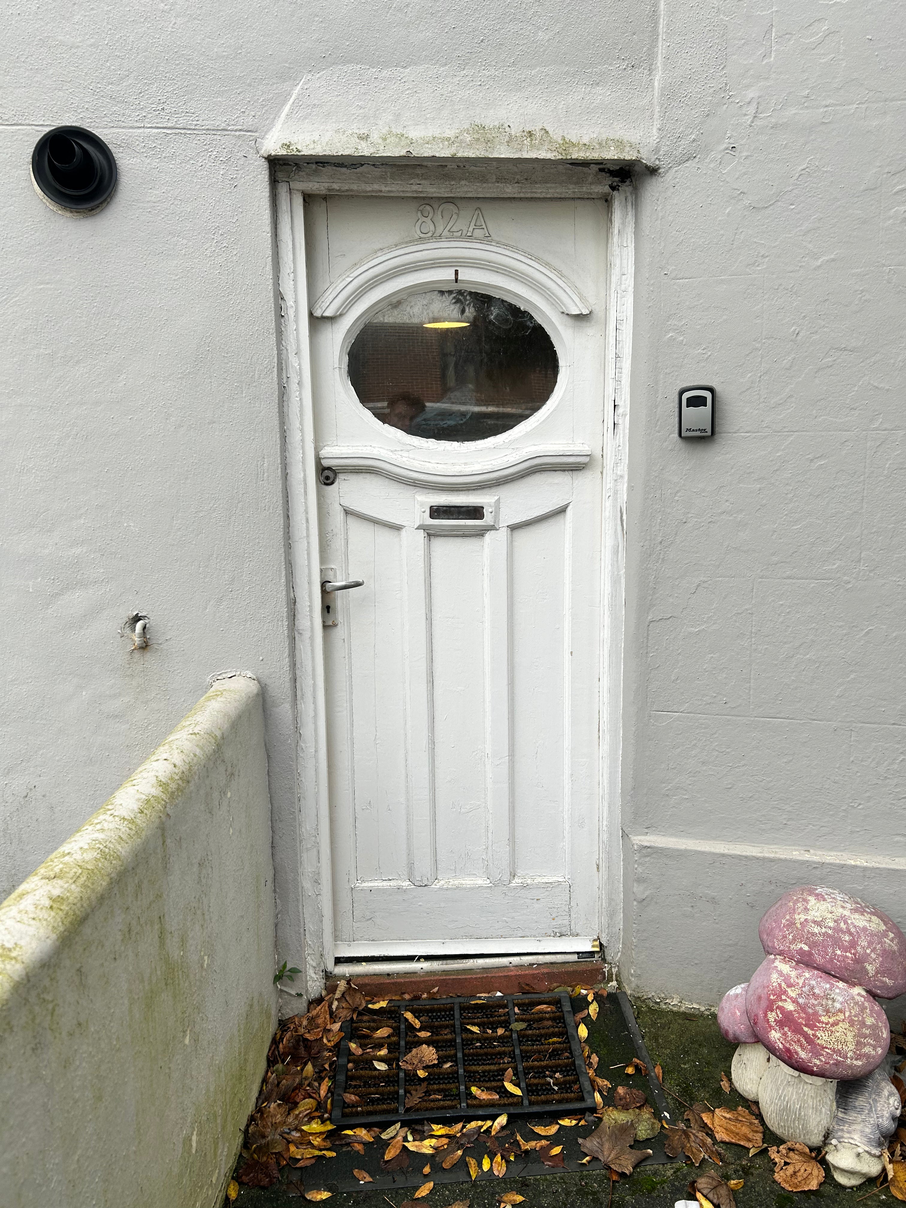 White door with a glass panel on a gray wall old needs replacing